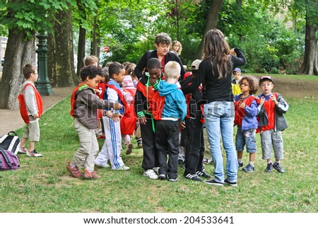 PARIS, FRANCE - JULY 10, 2012: group of french unidentified kids with two teachers in the city park  in Paris, France.