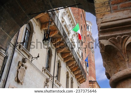 The flags of Italy and Europe in the facade of the Palazzo del Capitano, Piazza Dante, Verona, Italy