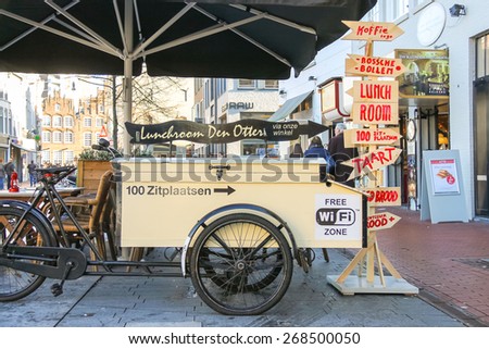 Den Bosch, Netherlands - January 17, 2015: People walk past the carriage for fast food, parked near the restaurant  in the Dutch town Den Bosch.
