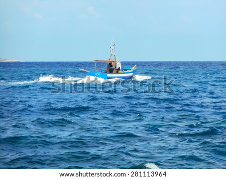 Favignana, Sicily, Italy - March 11, 2015: Fishermen on a boat out to fish in the ocean. Favignana, Italy