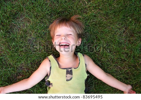 stock photo : Baby laughing, lying on the grass
