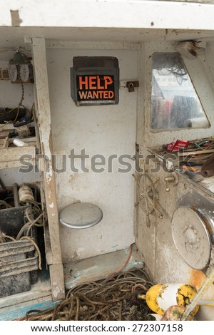 Gloucester, MA USA, April 14, 2015. Help wanted sign on an old lobster boat in the harbor.