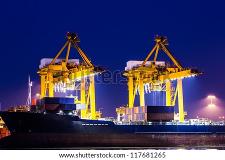 crane working with container cargo in shipyard at dusk