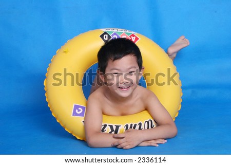 Chinese boy in swimming suit with swimming ring