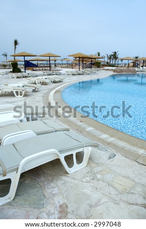 Waiting for tourists - pool chairs at a resort pool in a morning