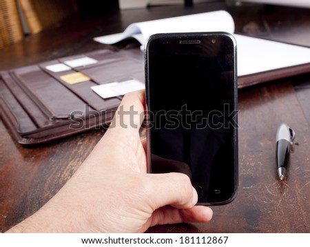 Old fashioned leather folder with blank paper and a modern smartphone