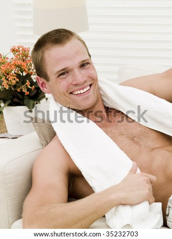 Muscular man with a towel getting a rest after working out