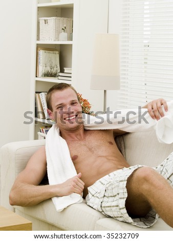 Muscular man with a towel getting a rest after working out
