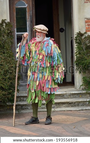KENTWELL HALL SUFFOLK UK  May 05, 2014: Old Man with grey beard in May Day re-enactment standing with stick