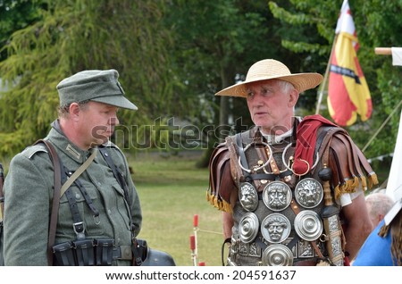 Military Tattoo  COLCHESTER ESSEX UK 8 July 2014:   Roman soldier chatting to German soldier in re-enactmentl