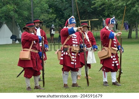 Military Tattoo  COLCHESTER ESSEX UK 8 July 2014:   Row of redcoat soldiers with guns  in recreation