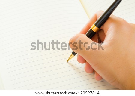 Close up of male hand signing a contract on blank white paper.