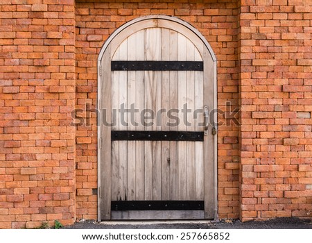 Wood arch door on  red brick wall background