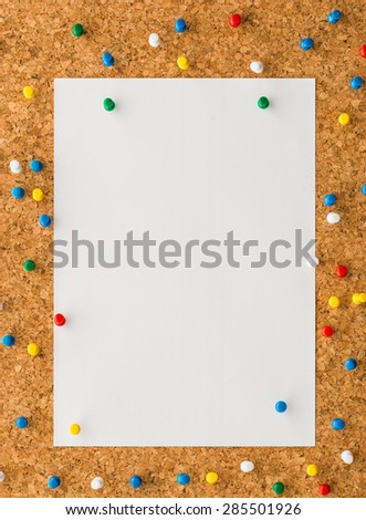 close up Blank white paper note sheet with multicolored push pin on cork board background for write memo