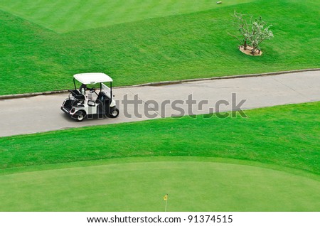landscape picture of a golf court with golf cart