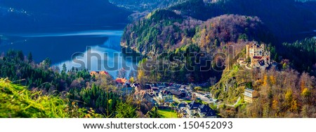 Hohenschwangau Castle with village on left, near the Neuschwanstein Castle, Germany. View from south-east, Castle on the right, Alpsee on the left.