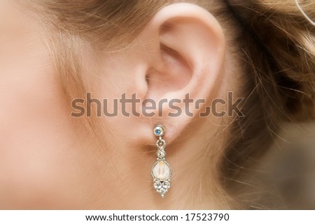 Close up of a brides ear with a pearl and diamond earring