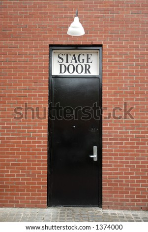Black stage door with light above.