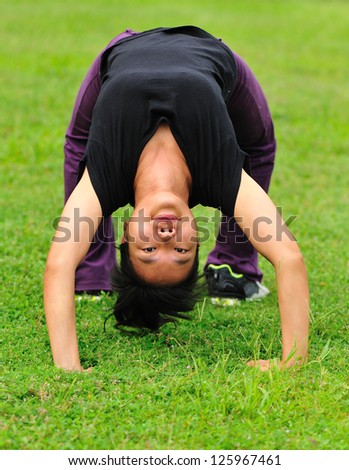 Woman back-bend on green grass