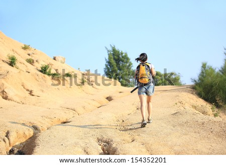 young asian woman hiker hiking on desert mountain
