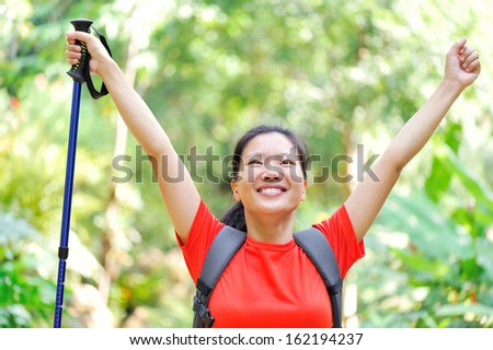 woman hiker raised arms in jungle