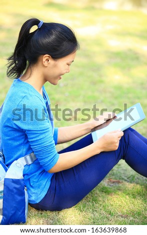 woman college student use tablet pc sit on grass