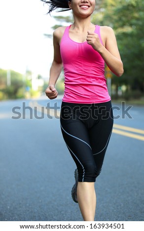 sports marathon woman running at city street