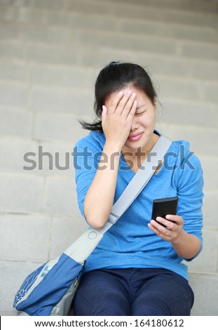 frustrated woman college student with cellphone sit on stairs with a bad news received from the cellphone message