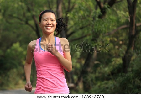 healthy fit woman runner running in forest trail