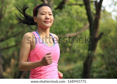 healthy fit woman runner running in forest trail