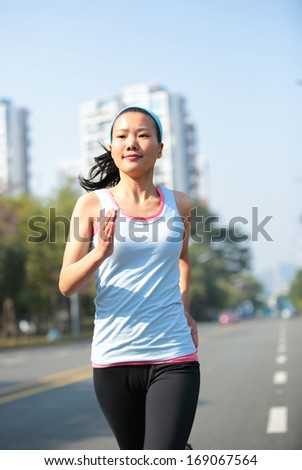 healthy sports woman running at city asphalt street