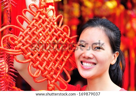 young asian woman with red chinese knot wishing you a happy chinese new year