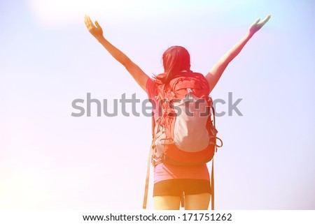 hiking woman stand mountain peak looking at the view with arms open