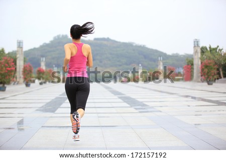young healthy asian woman jogging at city in the morning