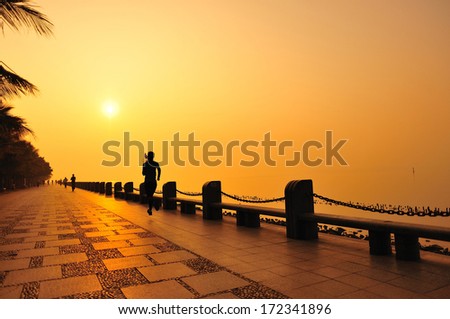 Runner athlete running at seaside. woman fitness silhouette sunrise jogging  workout wellness concept.