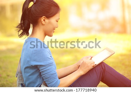 woman college student use tablet pc sit on grass