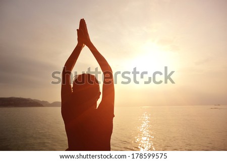 back of healthy yoga woman meditation at sunrise seaside