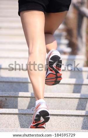 woman runner\'s legs running up on mountain stone stairs to the peak