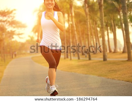 healthy lifestyle young asian sporty woman jogging at tropical park