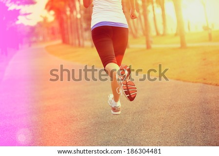 Runner athlete running at tropical park. woman fitness sunrise jogging  workout wellness concept.