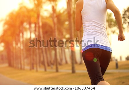 healthy lifestyle young asian sporty woman jogging at tropical park