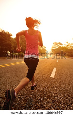 Runner athlete running at road. woman fitness  sunrise jogging  workout wellness concept.