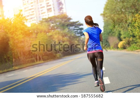 runner athlete running on road. woman fitness jogging workout wellness concept