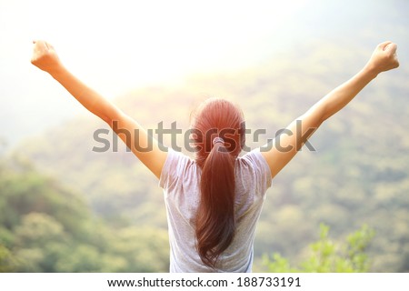 cheering  woman enjoy the beautiful view at mountain peak