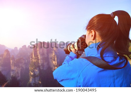 woman photographer taking photo at zhangjiajie national forest park,china