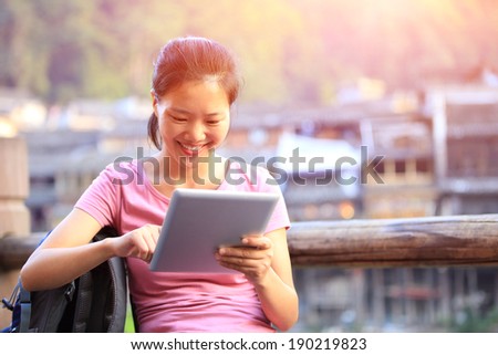 young asian woman use tablet pc at fenghuang ancient town,china