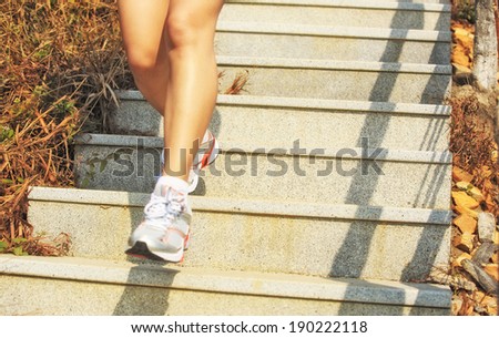 Runner athlete legs running on mountain stone stairs. woman fitness jogging workout wellness concept.