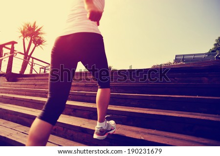 Runner athlete running on wooden stairs. woman fitness jogging workout wellness concept.