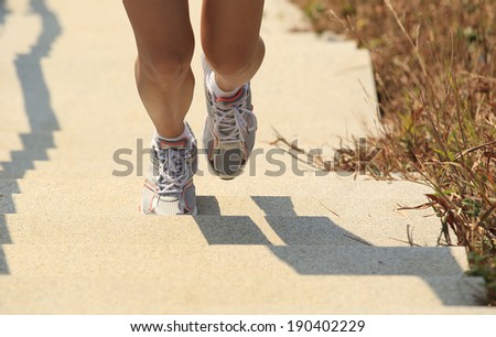Runner athlete legs running on mountain stone stairs. woman fitness jogging workout wellness concept.
