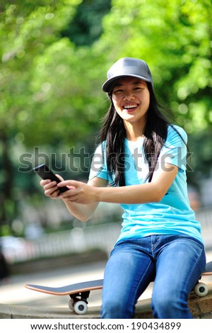 woman skateboarder sit on stairs use her cellphone